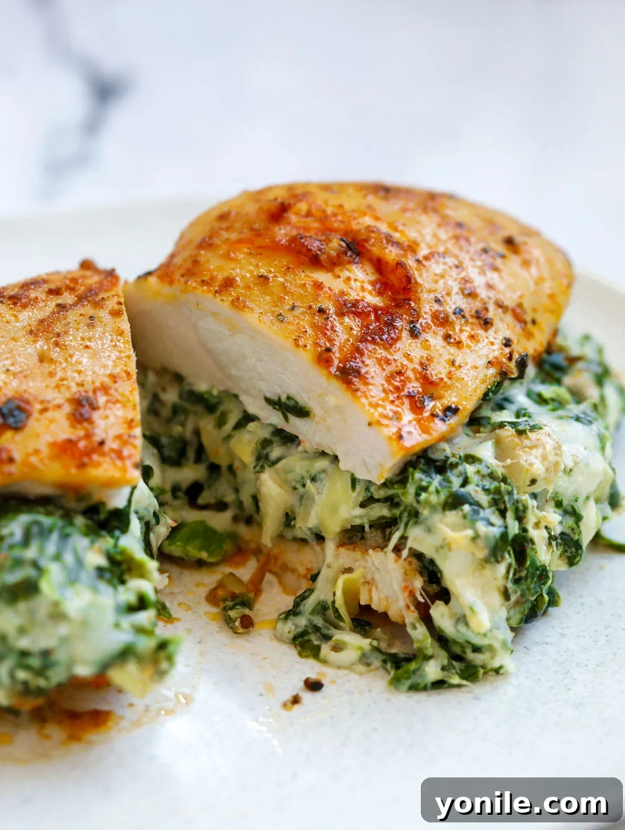 Close up of Spinach stuffed chicken breast cut in half, showcasing the creamy filling.