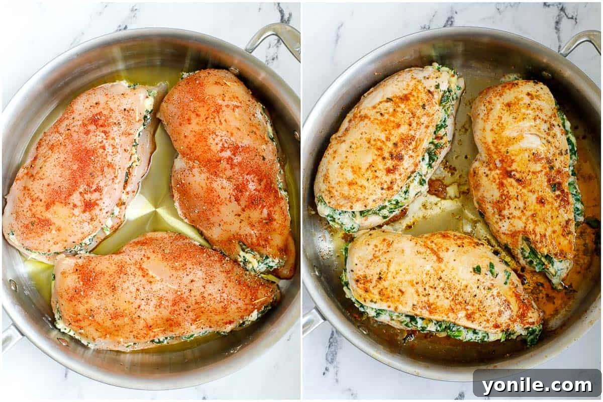 Three spinach stuffed chicken breasts sizzling in a hot skillet, achieving a golden sear.