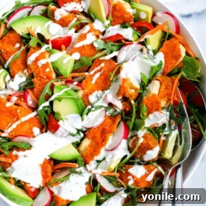 Top-down shot of a beautifully presented Crispy Buffalo Chicken Salad in a white bowl, ready to be enjoyed.