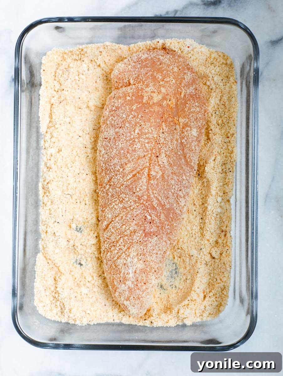Raw chicken breast, both sides coated with seasoned flour mixture.