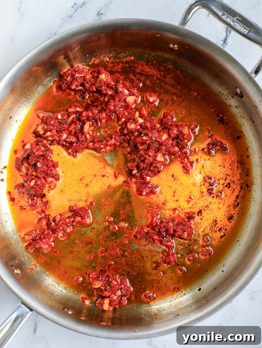 Top-down shot of mixing paste with aromatics.