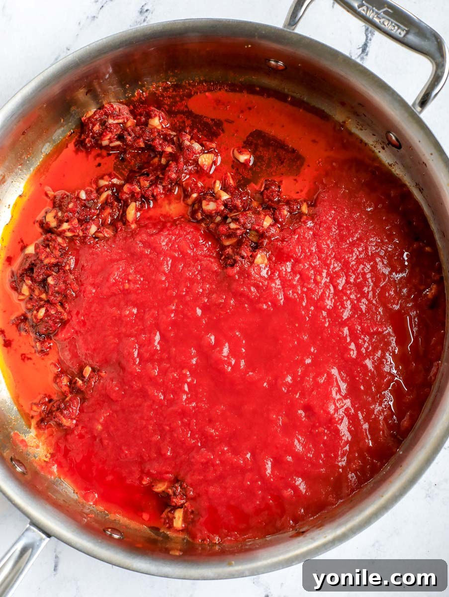 Adding crushed tomato sauce to the pot.