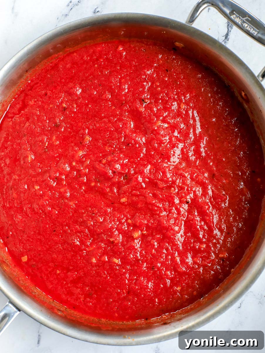 Top-down shot of tomato sauce simmering in a pot.