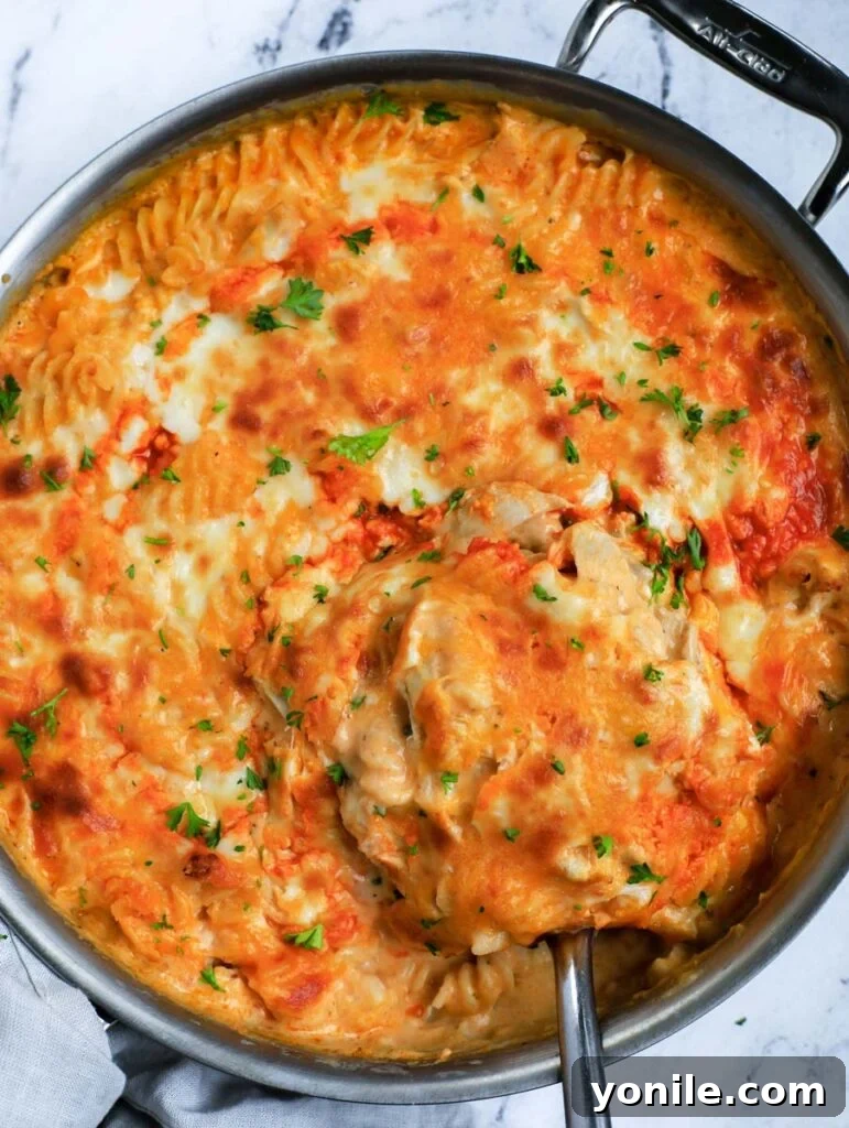 A freshly baked pan of Buffalo Chicken Mac and Cheese, with a golden, bubbly cheese crust and a hint of buffalo sauce drizzle.