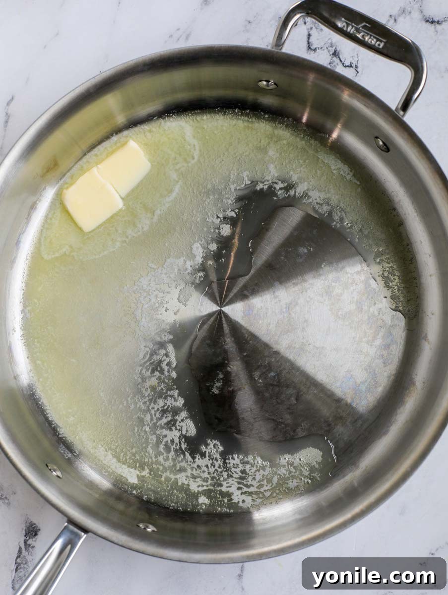Melted butter simmering in a large skillet, ready for flour.