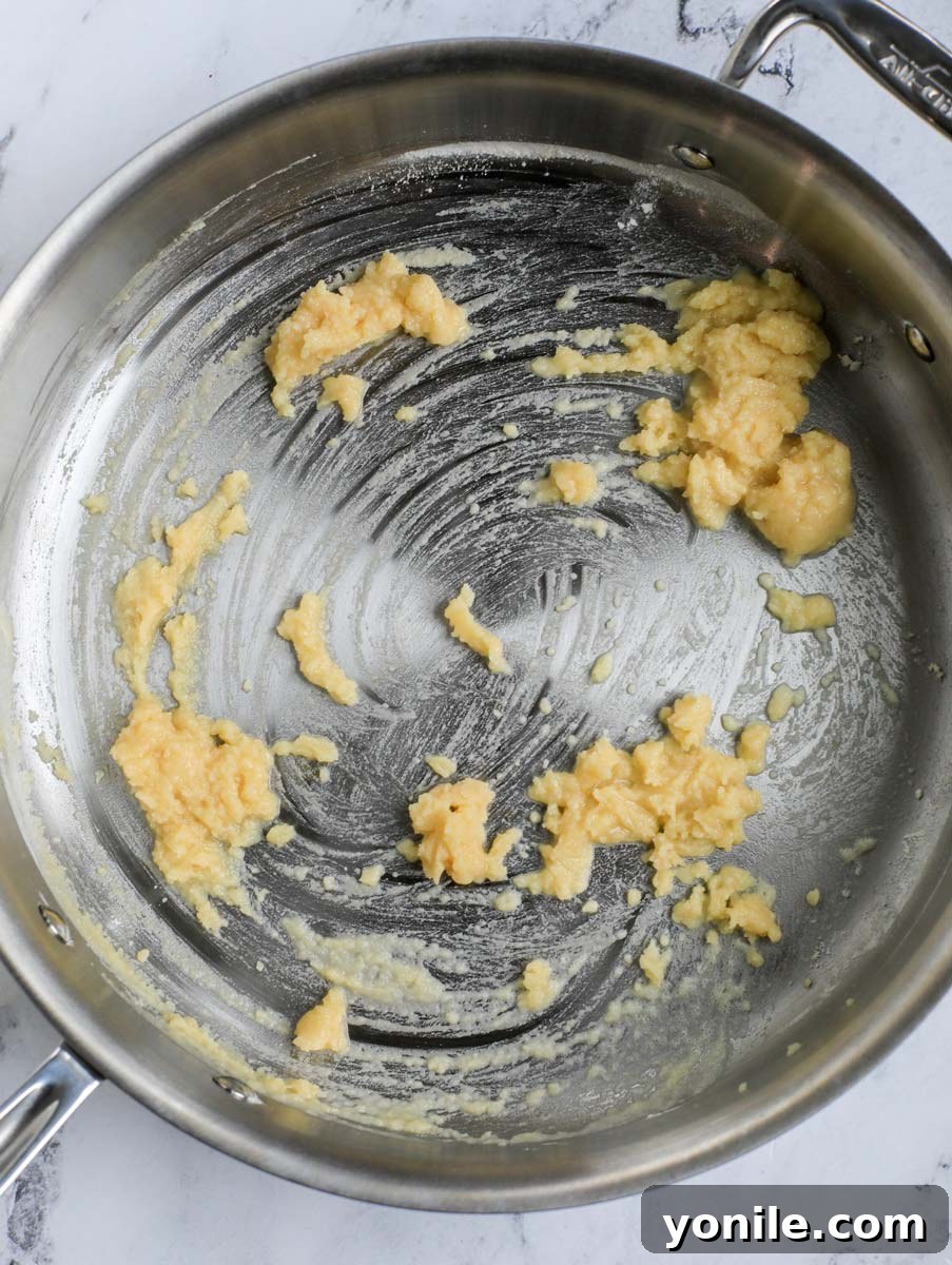 Butter and flour forming a smooth, golden paste (roux) in a pan.