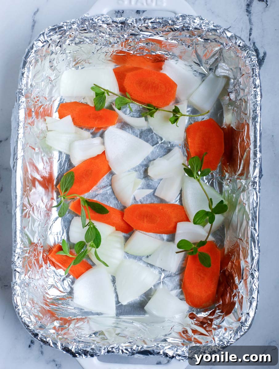 Add in the onions, oregano and carrots in a tin foil lined pan