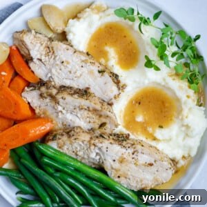 plate of oven baked turkey with mashed potatoes, gravy, and vegetables