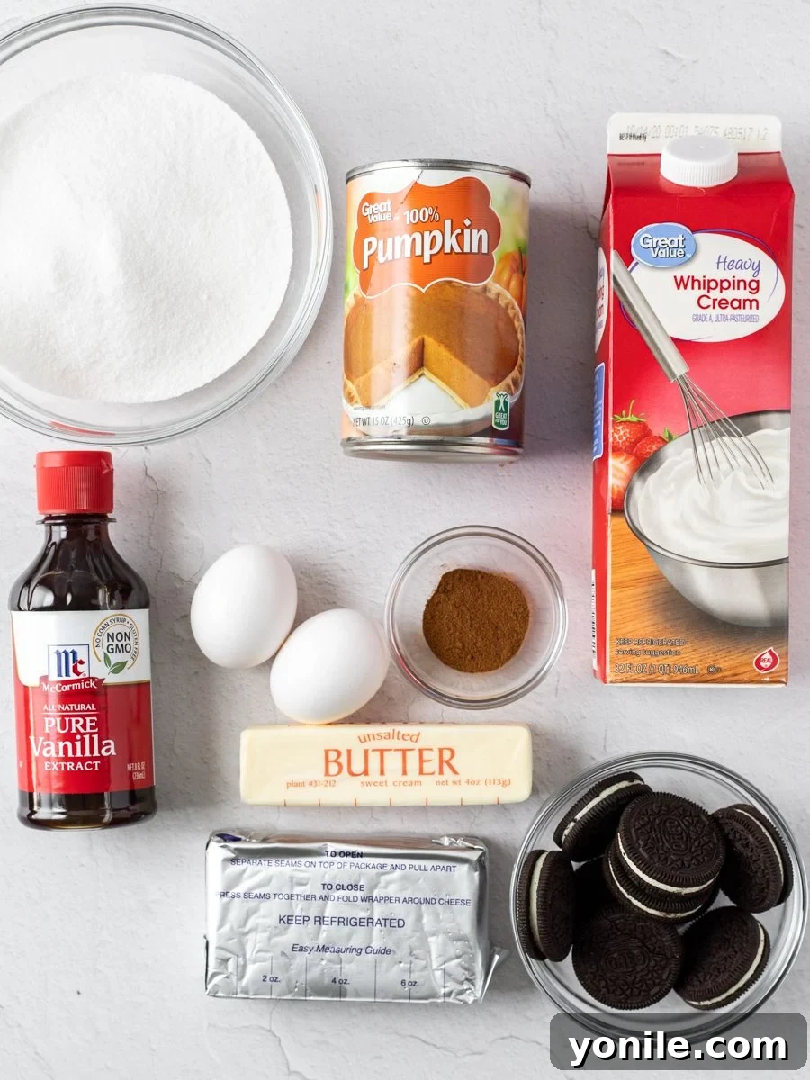 Top down shot of all fresh ingredients laid out for making mini pumpkin cheesecakes, including pumpkin puree, cream cheese, eggs, and Oreos.
