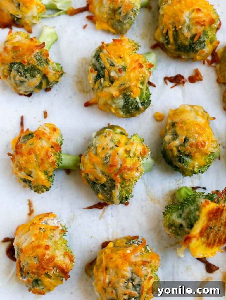 Golden Broccoli Cheese Poppers 8 Cheesy broccoli bites on a baking sheet.