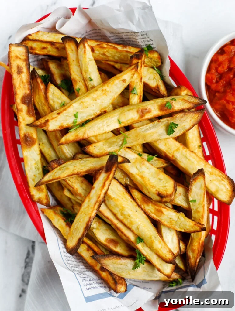 Top down shot of crispy sweet potato fries in a red basket, ready to be served.