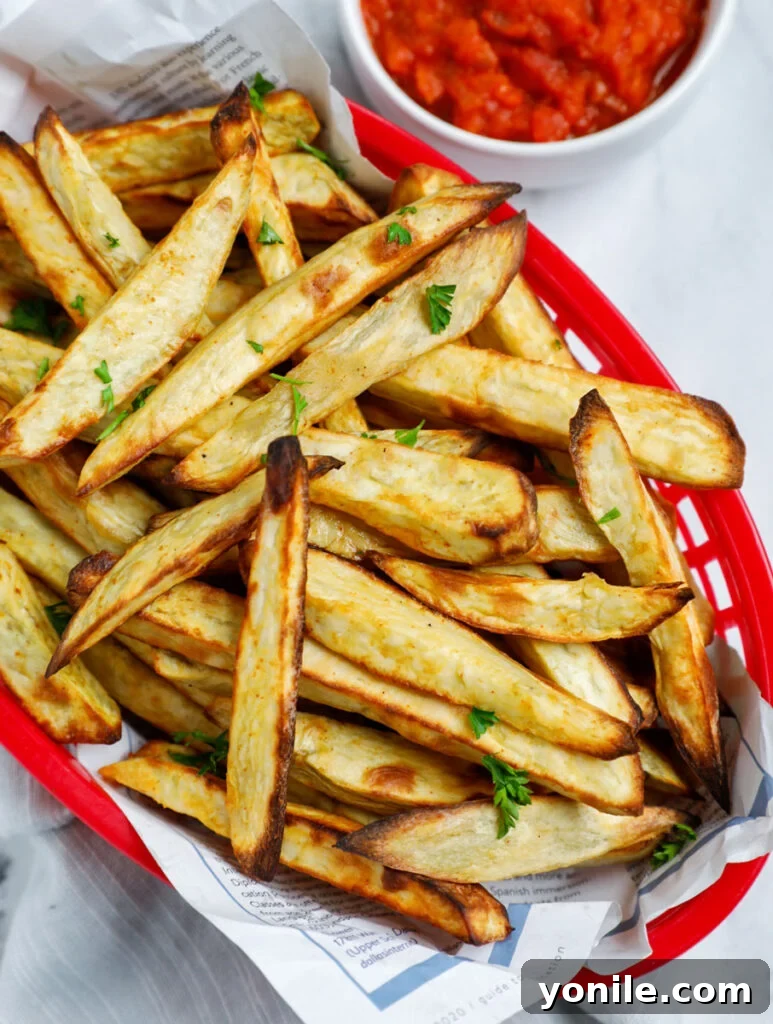Overhead shot of a basket of golden air-fried sweet potato fries.