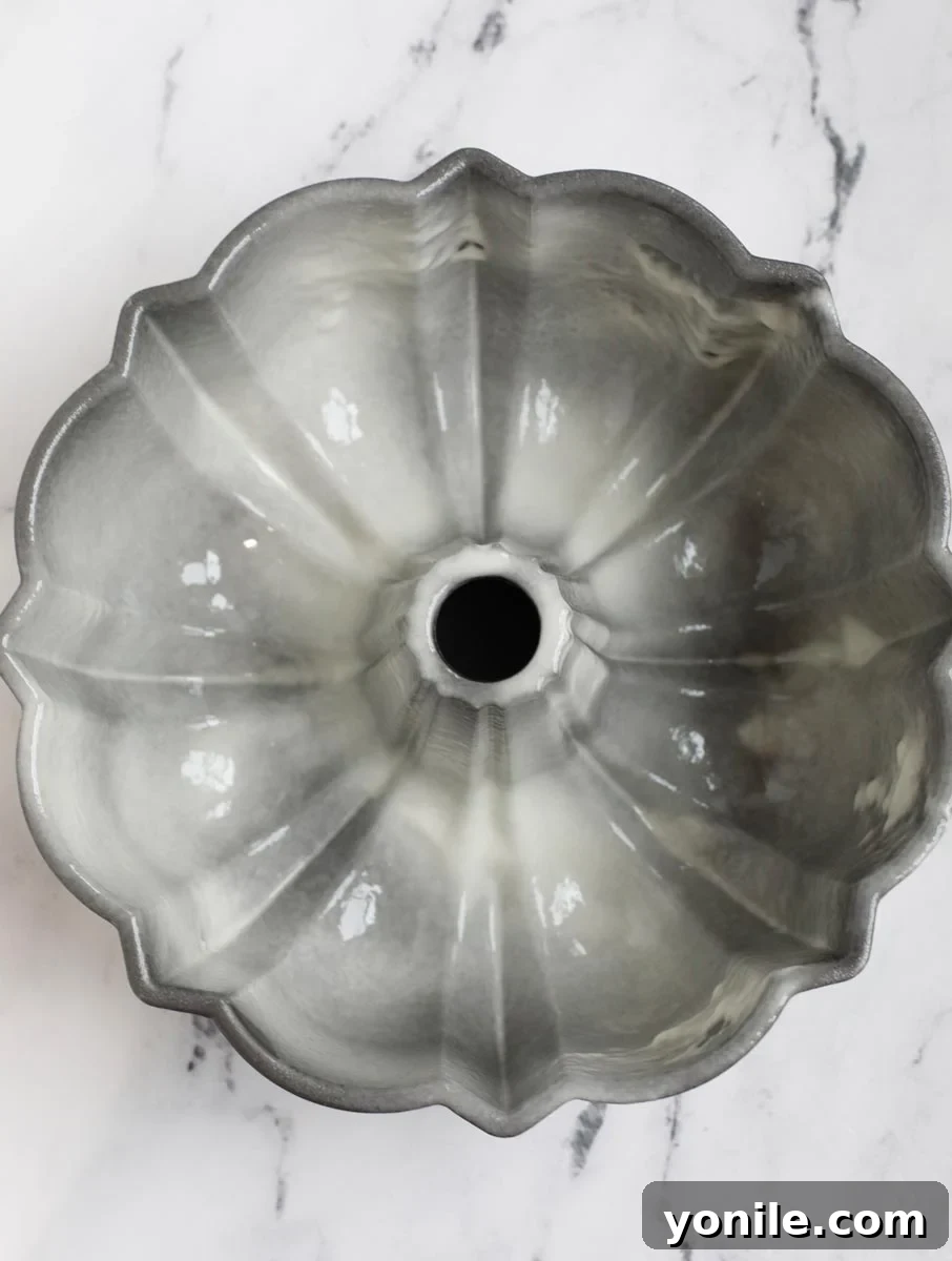 A Bundt cake pan generously sprayed with non-stick baking spray, ensuring the cake won't stick.