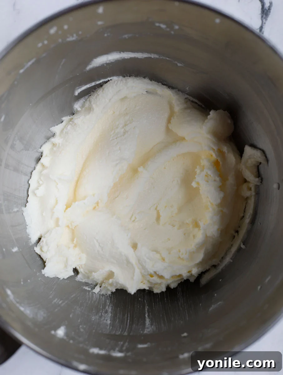 The butter and sugar mixture after being whipped into a fluffy, pale cream, showing good aeration.