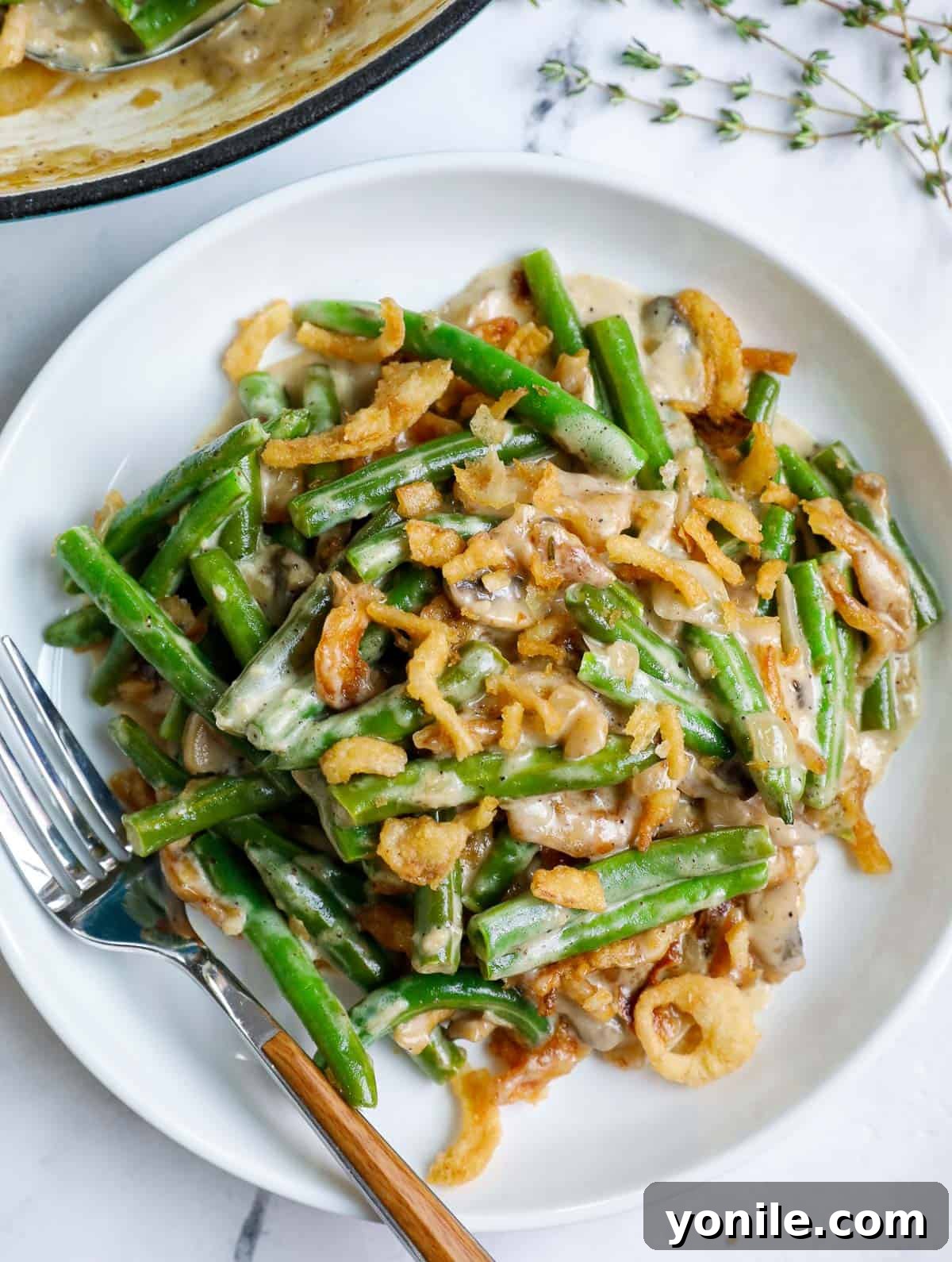 A serving of homemade green bean casserole presented beautifully on a white plate, garnished and ready.