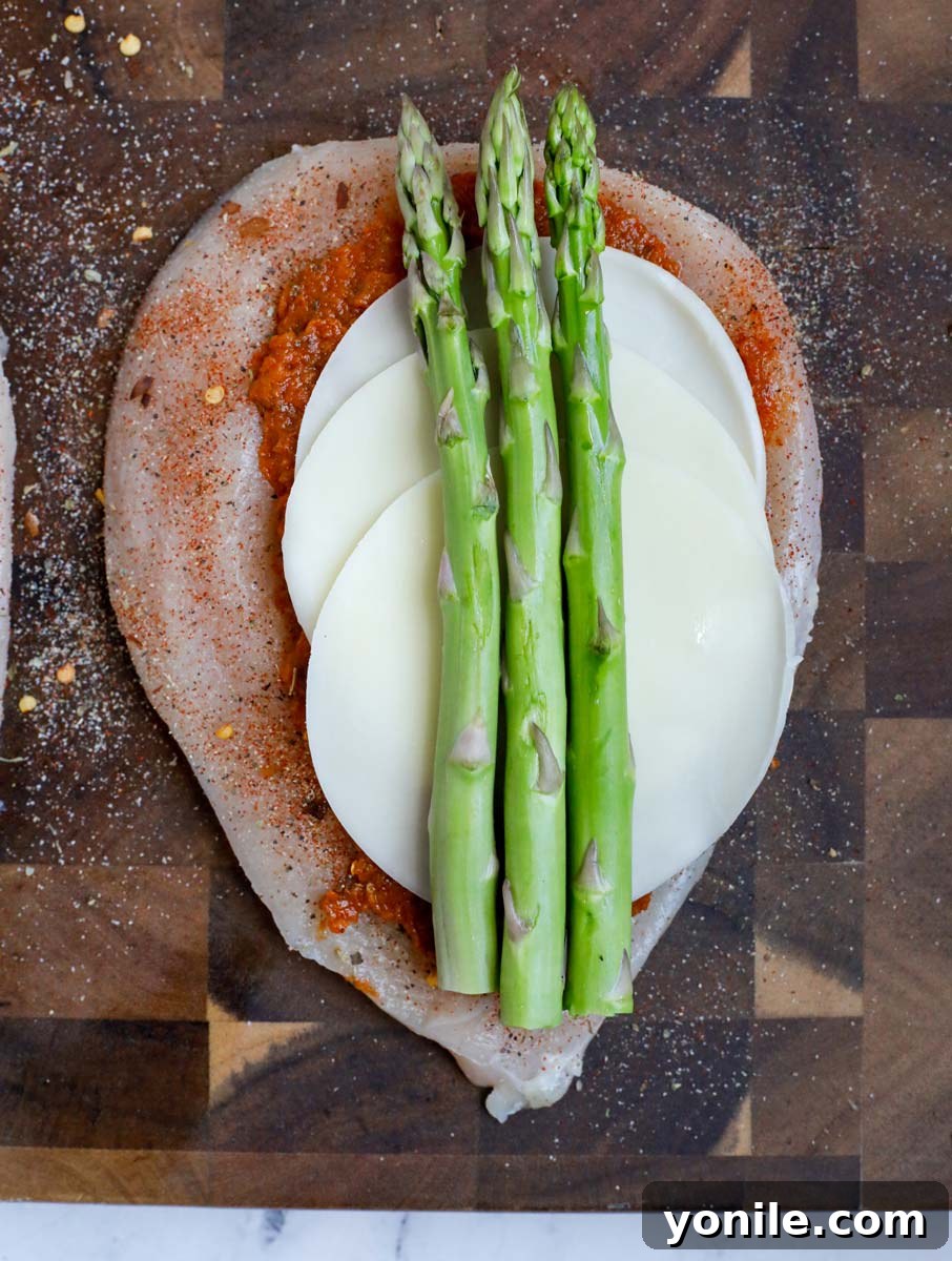 Chicken breast with pesto, cheese and asparagus.
