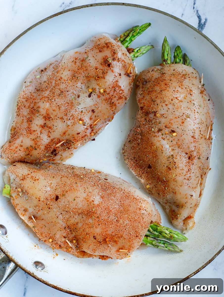 Three stuffed chicken breast in a skillet.