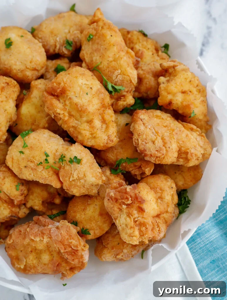 Homemade Chicken Nuggets: Crispy, Juicy, Perfect 2 Top down view of crispy homemade chicken nuggets on a plate, ready to be served.