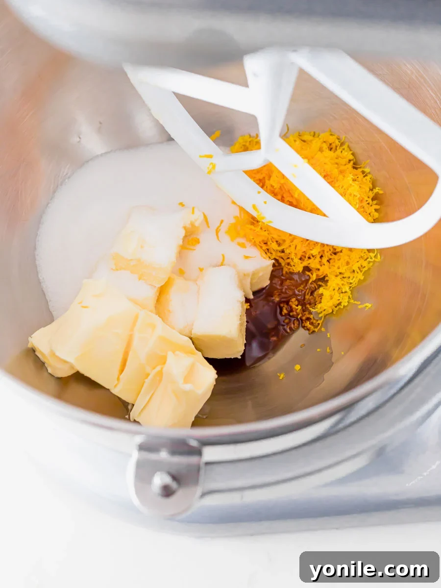 Zesty Cranberry Orange Butter Cookies 4 Close-up of butter, sugar, vanilla, and orange zest being creamed in a stand mixer bowl.