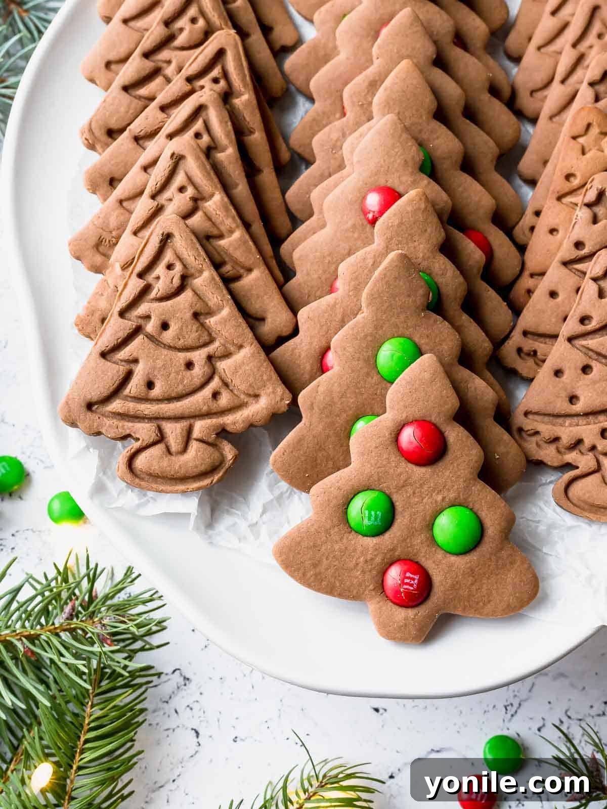 christmas tree gingerbread cookies on a white plate, beautifully decorated for the holidays