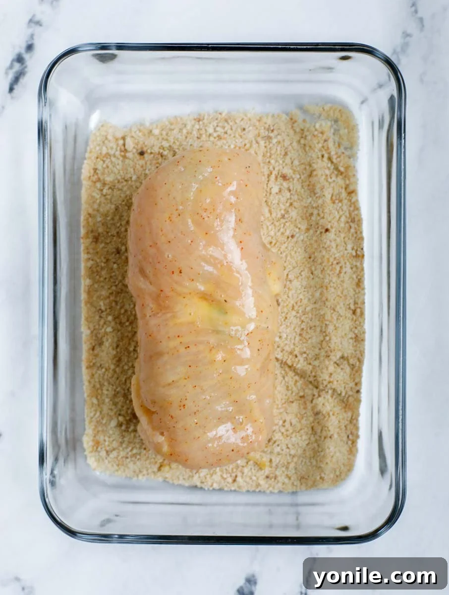Creamy Jalapeño Chicken Popper 11 Stuffed chicken breast coated in seasoned flour, ready for egg wash.
