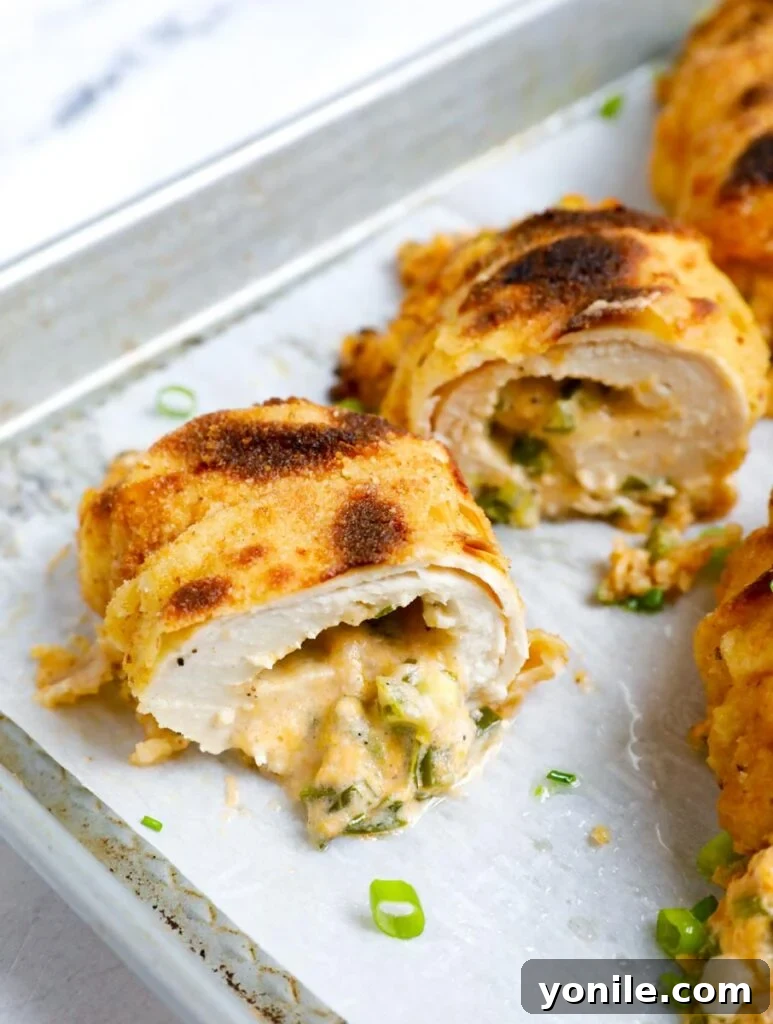 Creamy Jalapeño Chicken Popper 13 Jalapeno popper chicken, perfectly sliced and displayed on a baking sheet, showcasing the creamy filling.