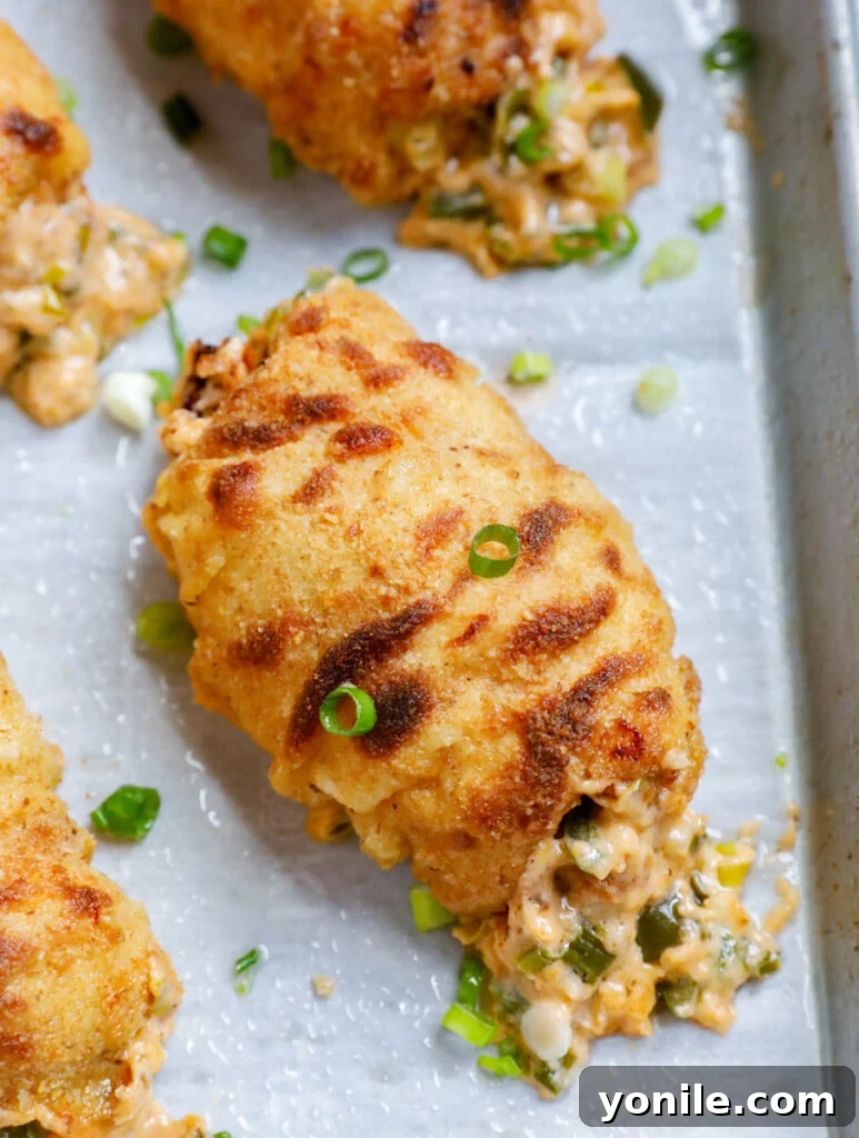 Creamy Jalapeño Chicken Popper 14 Overhead view of perfectly baked jalapeno popper chicken rolls on a baking sheet, golden and delicious.