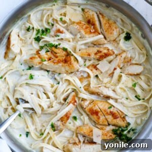 Top down shot of creamy chicken alfredo stirred in a pot.