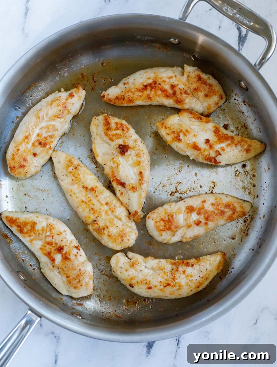 Chicken turning golden in a pan.