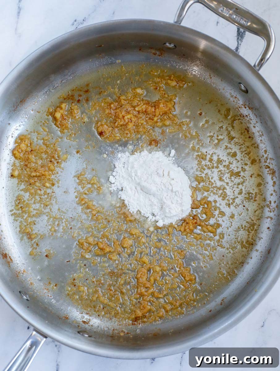 Cooking garlic and seasoning in a pan.