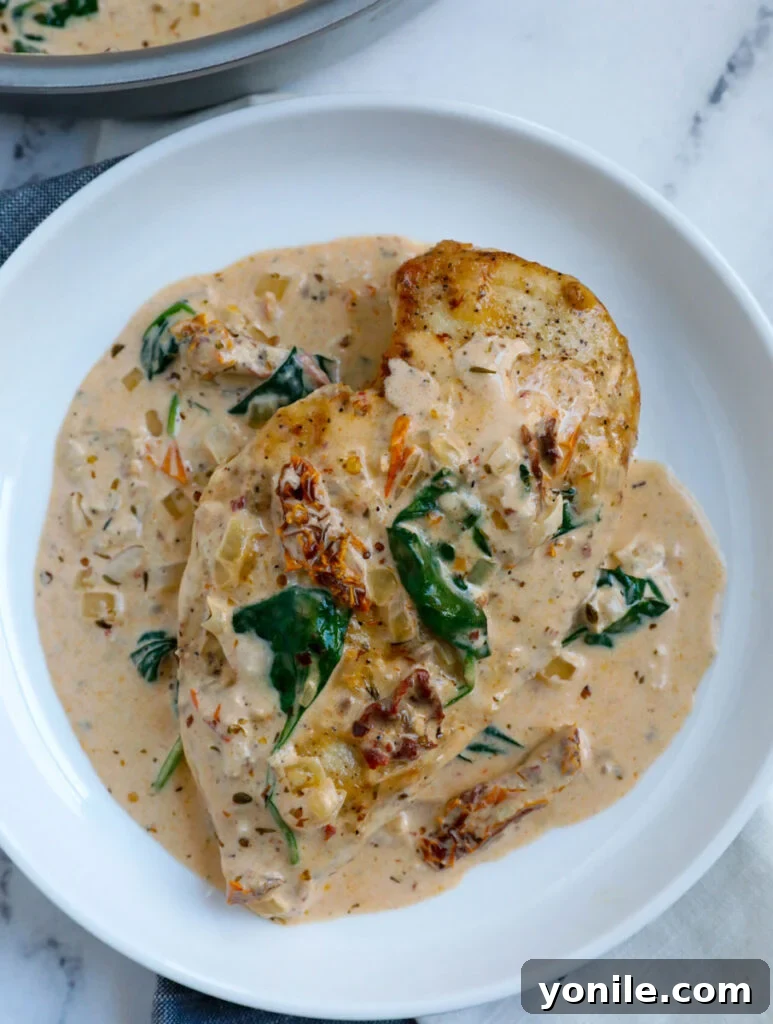 piece of creamy chicken tuscan breast on a white plate