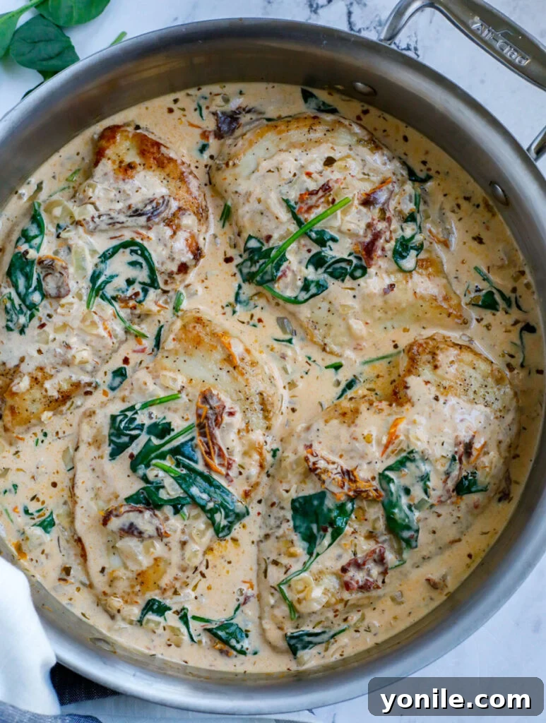 Top down view of tuscan chicken in a silver pan.