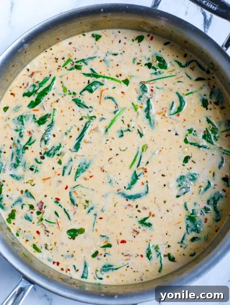 Spinach wilting into the cream sauce.