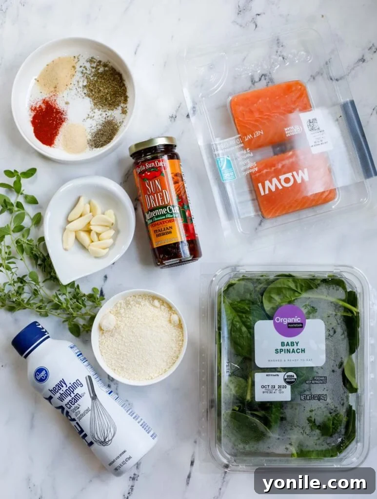 Top down view of ingredients for creamy Tuscan salmon spread out on a counter.