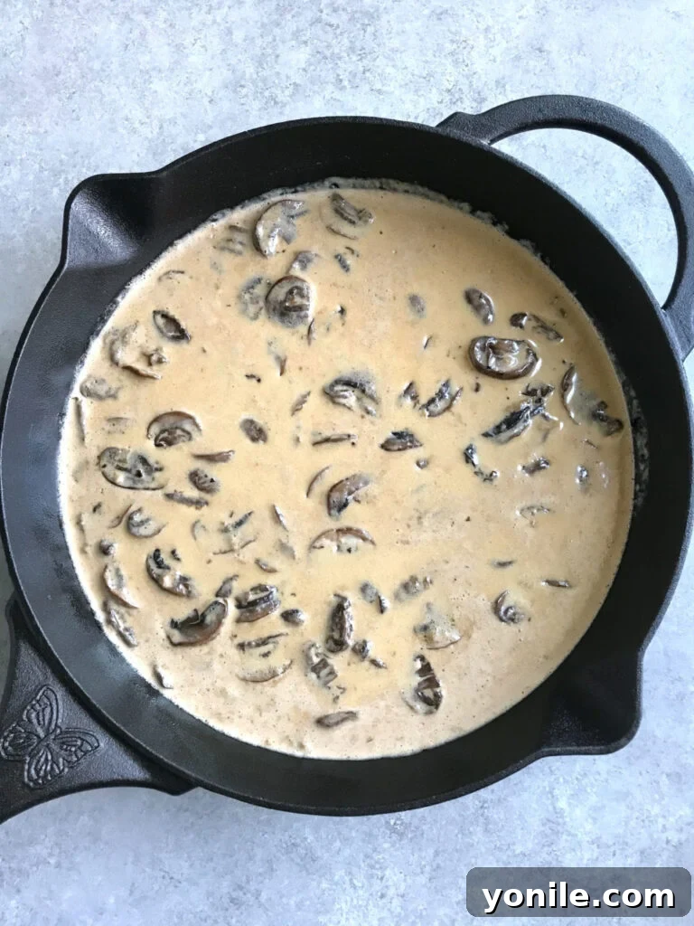 Creamy mushroom sauce simmering in a cast-iron skillet