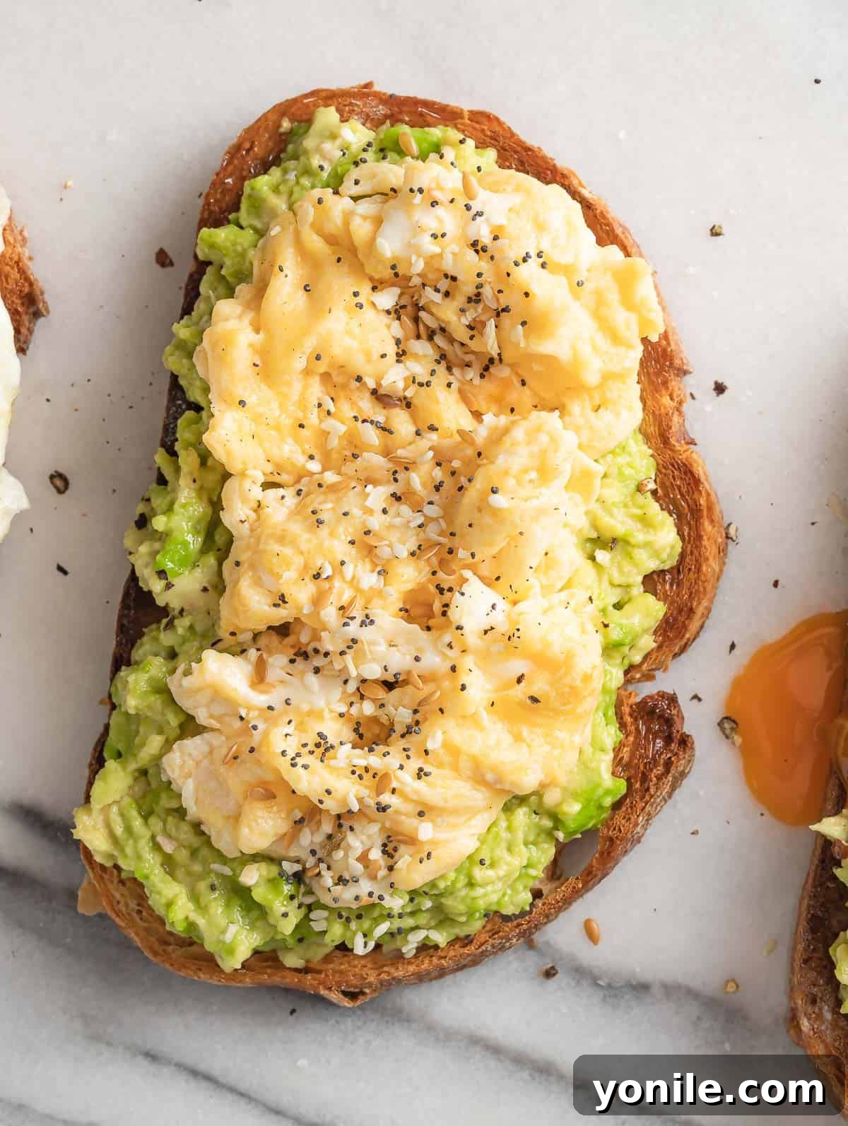 The Perfect Avocado and Egg Toast 4 Avocado spread on a slice of golden-brown toast, generously topped with soft, fluffy scrambled egg and a sprinkle of seasonings.