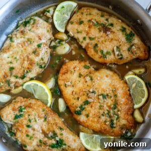 Top down shot of lemon and chicken in a skillet, representing the final dish, for nutritional context.