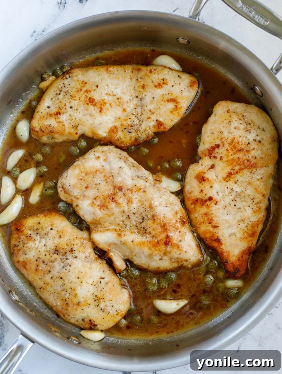 Lemon chicken piccata in a pan.