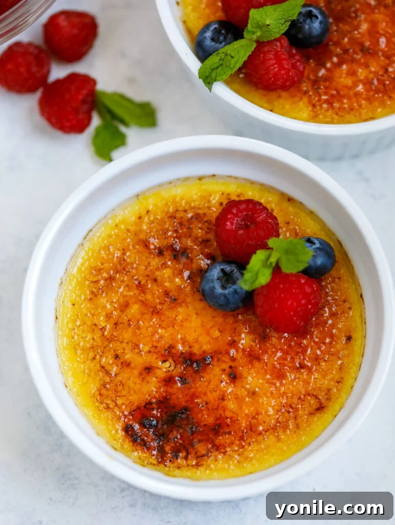 Top-down view of two perfectly made crème brûlées in white ramekins, ready to be served.