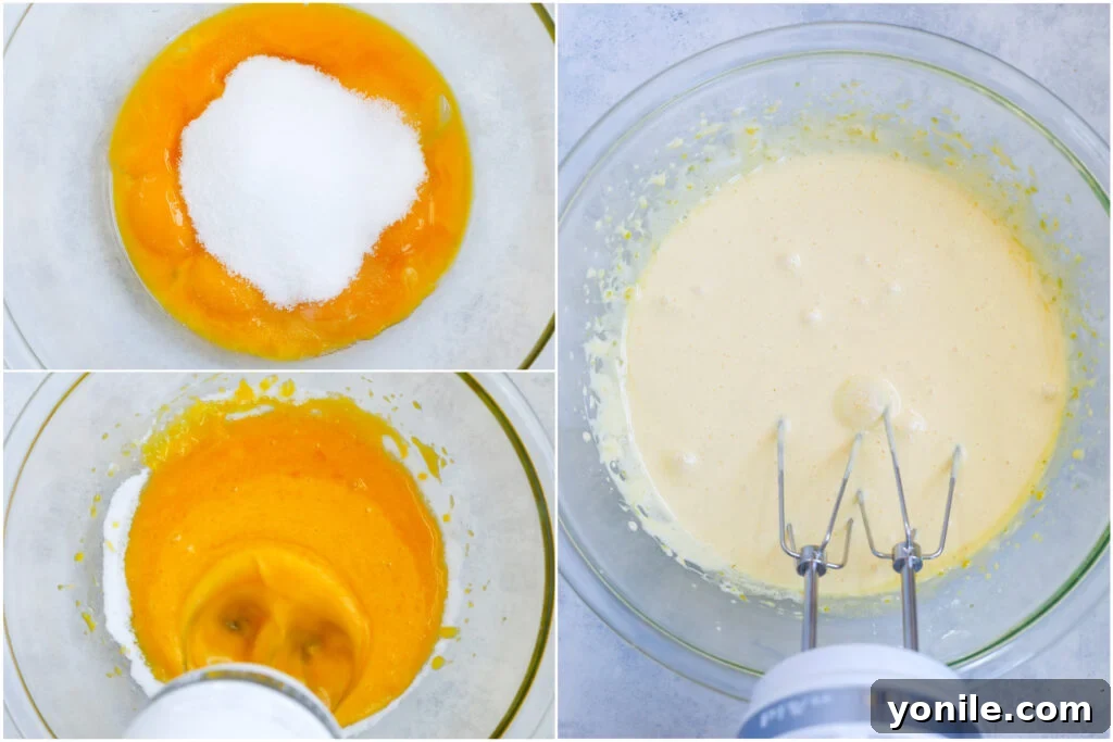 Hands whisking egg yolks and sugar vigorously in a mixing bowl until light and creamy.