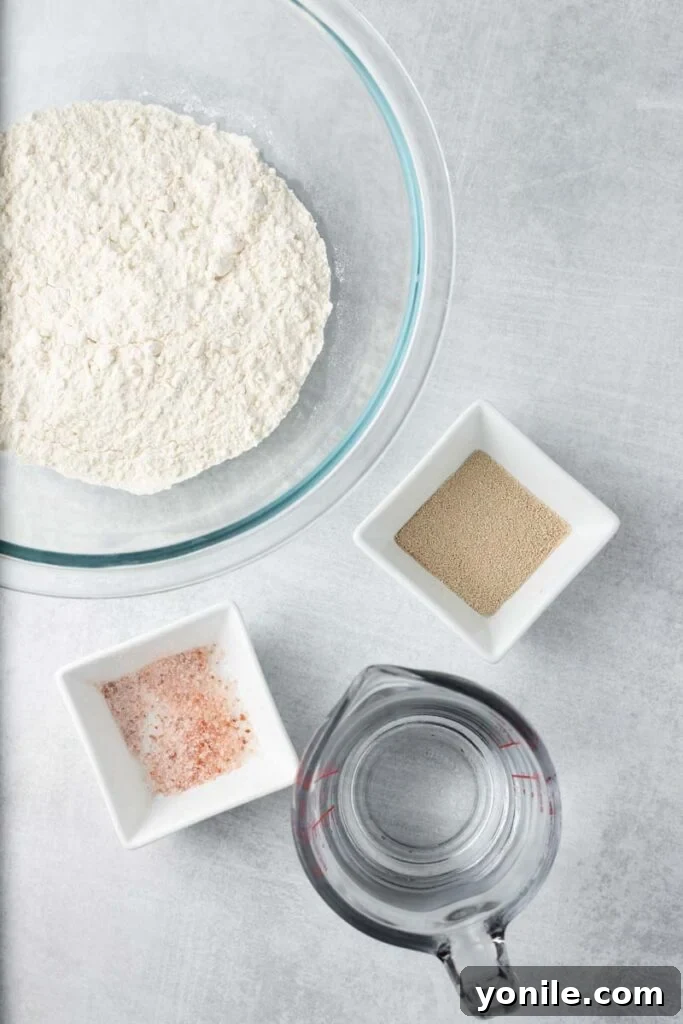 Effortless Artisan Loaf 3 Overhead image of ingredients for no knead bread arranged on a surface.