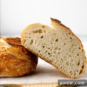 Half of a loaf of bread, cut, leaned overtop the other half of the bread.