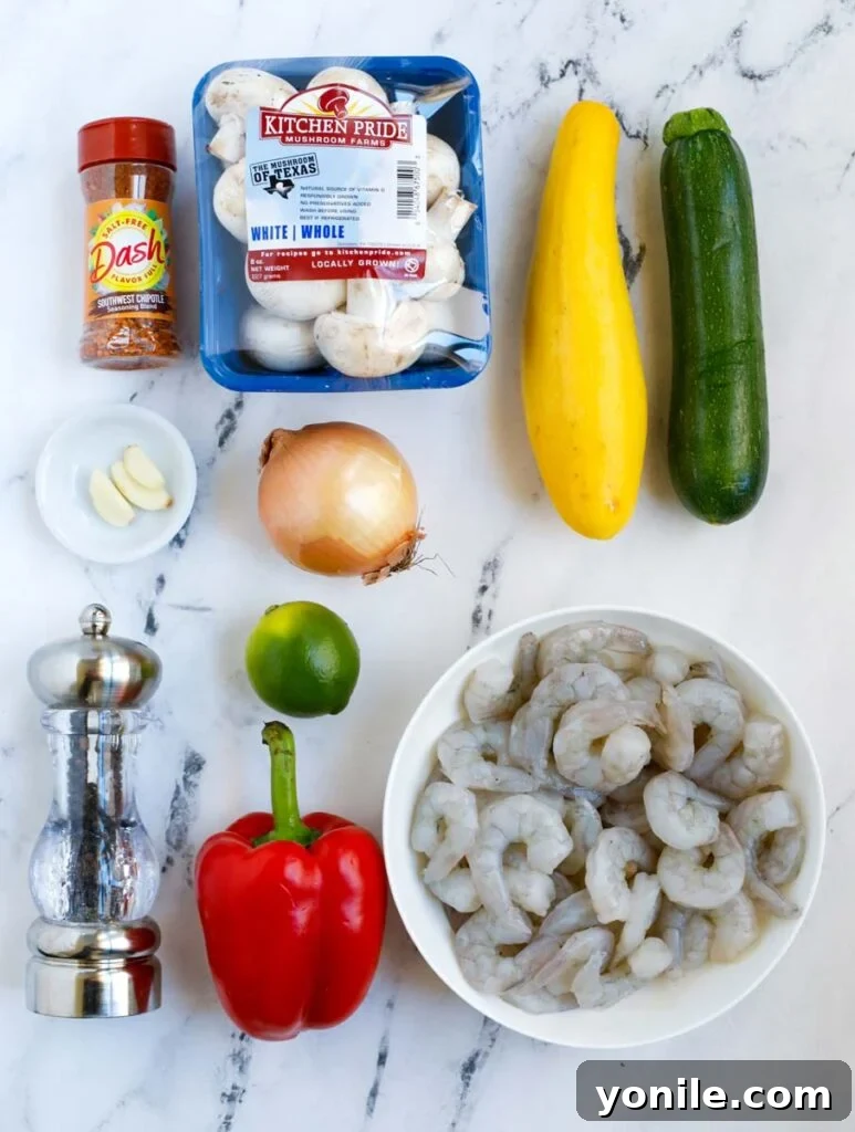 Top down shot of all ingredients for air fryer shrimp and vegetables laid out on a wooden board.
