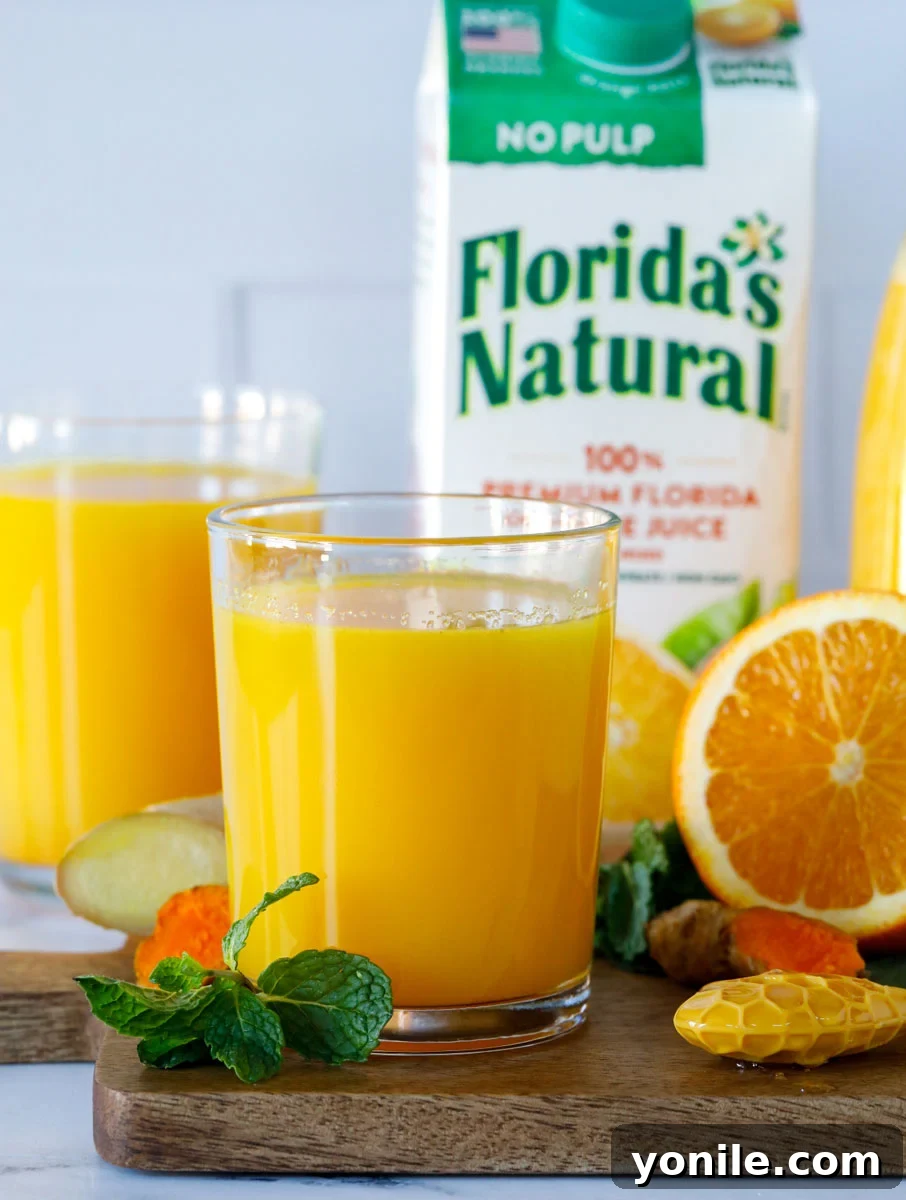 Citrus Immune Shield 3 Close-up view of a glass of Orange-Ade Immune Booster Drink, with a carton of Florida's Natural orange juice visible in the softly blurred background.