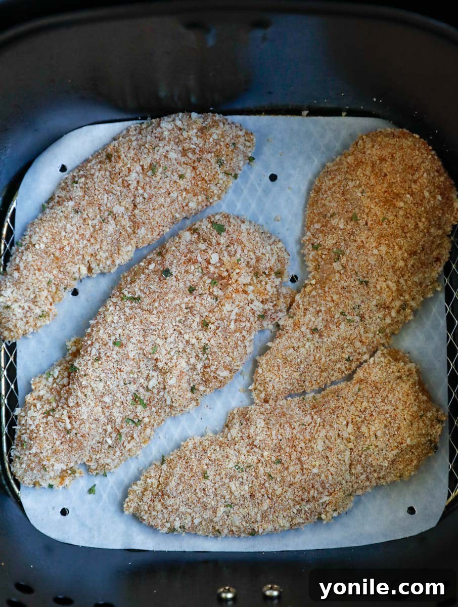Chicken tenders cooking inside an air fryer.