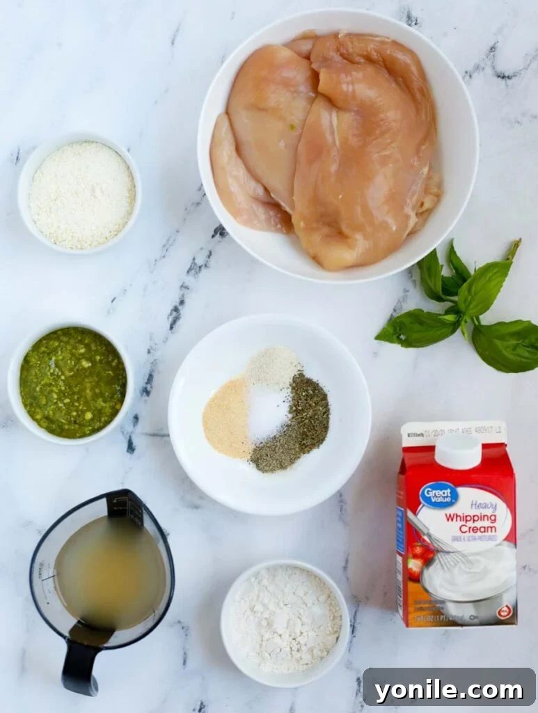 Dreamy Creamy Pesto Chicken 3 Top down shot of all ingredients for creamy pesto chicken laid out on a kitchen counter.