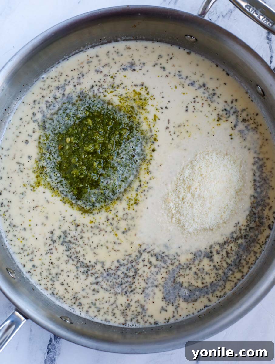 Dreamy Creamy Pesto Chicken 6 Adding pesto to the roux in the pan.