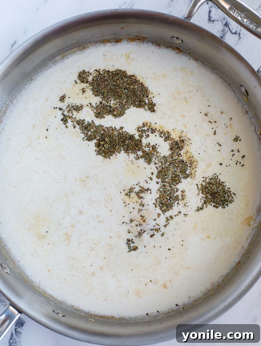 Dreamy Creamy Pesto Chicken 7 Heavy cream being poured into the pan to create the creamy sauce.
