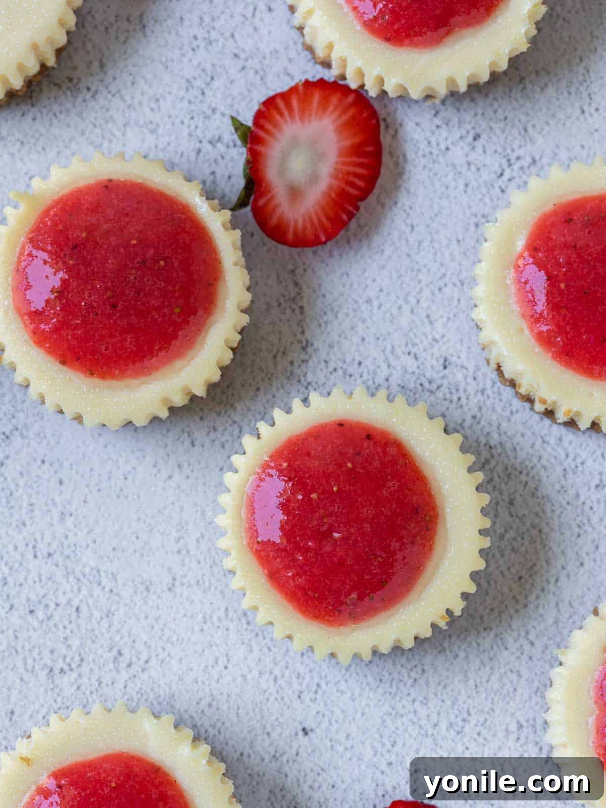 A top-down shot showing the creamy texture of the mini strawberry cheesecake filling before baking.