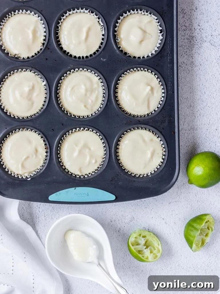 cheesecake filling in a muffin tin pan lined with cupcake holders
